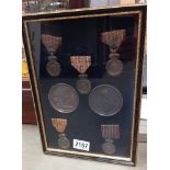 A quantity of French framed and glazed medals and medallions.