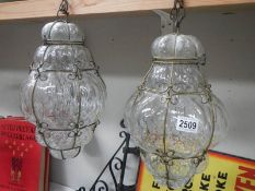 A pair of wire bound blown glass lanterns, approximately 40 cm drop.