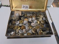 A tin of military buttons.