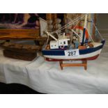 A model fishing boat and a model rowing boat.