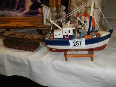 A model fishing boat and a model rowing boat.