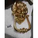 A brass lion door knocker.