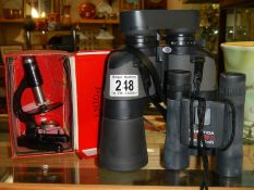 A cased set of binoculars and a microscope.