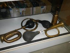 Three brass car horns with bulbs and one without bulb.