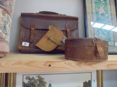 An old leather briefcase, a leather collar box and a gun holster.