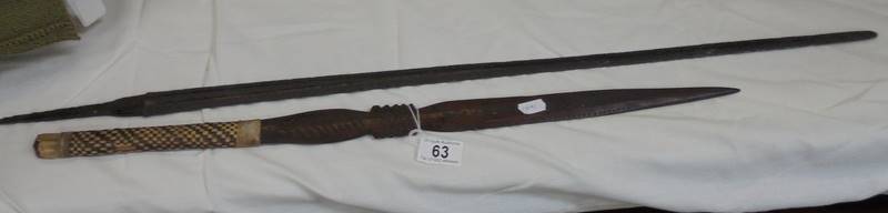 A sword blade and a wooden tribal weapon.
