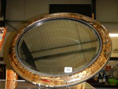 An oval bevel edged mirror with oriental decoration. COLLECT ONLY.