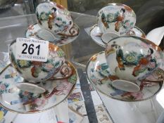 Four Japanese porcelain tea cups and saucers.