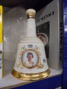 A Wade Bells whisky commemorative decanter with contents.