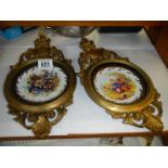 Two solid brass wall plaques with ceramic dishes in centre.