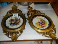 Two solid brass wall plaques with ceramic dishes in centre.