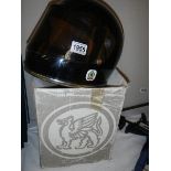 A boxed vintage Griffin black motorcycle helmet with tinted visor.