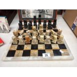 A mixed stone (including onyx) chess board with chess pieces