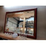 A dark wood framed bevel edge mirror