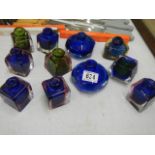 A quantity of coloured glass inkwells.