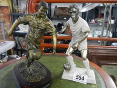 Two footballer figures in resin.