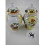 A pair of small hand painted lidded vases.