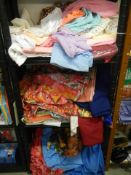 Three shelves of fabric and linen.