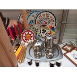 A colourful lot of table mats/coasters plus stainless steel tea set on tray, candlesticks, candles
