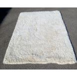 A cream coloured deep pile rug (214 x 151 cm) Collect Only