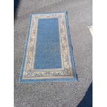 A Blue and Cream coloured floral patterned rug 150 x 83cm Collect only