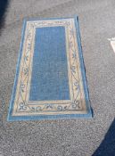 A Blue and Cream coloured floral patterned rug 150 x 83cm Collect only