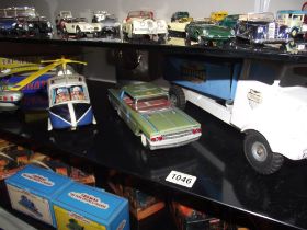 A tinplate battery operated helicopter and one other, clockwork police car, boxed train, roadway