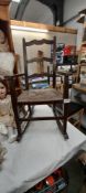 An Edwardian oak child's/dolls rocking chair with reed seat COLLECT ONLY