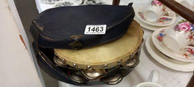 A vintage 1960's Salvation Army tambourine with ribbons and uniform bodice