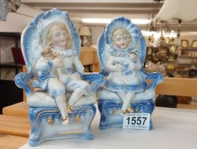 A pair of continental bisque seated figures