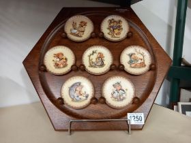 A Goebel/M J Hummel wooden wall plaque with 7 small Goebel collectors plates