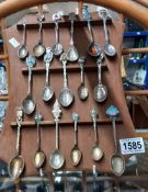 A display of tourist collectors spoons including silver and enamelled examples
