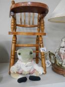 A wooden doll high chair with a Beatrix Potter frog soft toy. COLLECT ONLY.