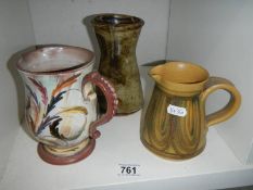 A studio pottery vase and two jugs.