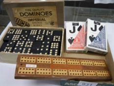 A boxed set of double nines Imperial dominoes, a crib board and two packs of cards.