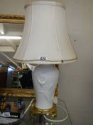 A white porcelain table lamp on a brass base.