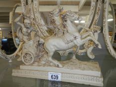 A composite figure of a Roman chariot with horses.