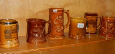 A quantity of brown glazed souvenir tankards including Jamaica Inn, Jersey and Scotland.