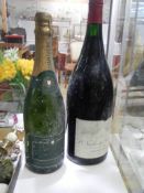 An old bottle of Pierre De Bry champagne and a bottle of red wine.