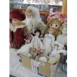 A collection of porcelain dolls and a Hug Me rag doll.