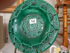 A green glazed pottery collector's plate.