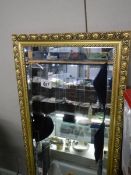 A gilt framed bevel edged mirror, 97 x 37 cm. COLLECT ONLY.