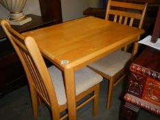 A light oak table and two chairs, COLLECT ONLY.