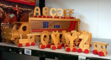 A vintage wooden pull-a-long lorry, the trailer holds a complete set of the alphabet on wheels etc