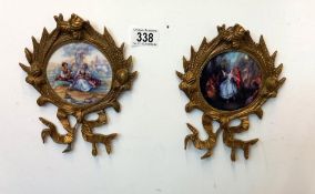 A pair of ornate brass wall hangings with floral pattern pottery plaques