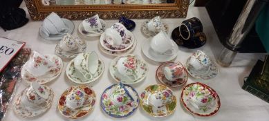 A good selection of vintage china cups and saucers, including a trio