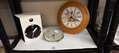 A modern cuckoo clock, wall clock and a vintage alarm clock
