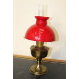 Brass oil lamp with red glass shade {55 cm H x 24 cm Dia.}.