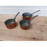 Set of three graduated copper saucepans with wrought iron handles {14 cm H x 33 cm W x 17 cm D to 18