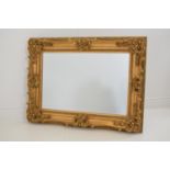 Decorative gilt wood overmantle mirror with bevelled glass {90 cm H x 120 cm W}.